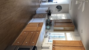 A kitchen with wooden cabinets, a microwave, and a stove. - Close to beautiful beach (Avalon)