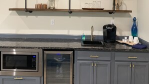 A kitchen with a microwave, oven, and built-in shelves above the counter. - Salado Cottage Retreat near Downtown (Salado)