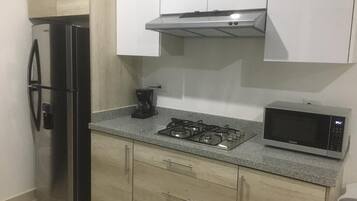 Fridge, microwave, coffee/tea maker, cookware/dishes/utensils