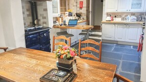 Una mesa de madera con un centro de mesa floral y un ordenador portátil encima.
