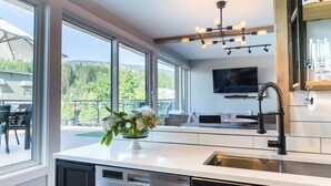 Uma cozinha moderna com lava-louças, pia e área de refeições com mesa e cadeiras.