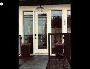 Stylish entrance with a black metal gate and potted plants.