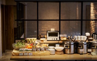 Montaje de bufé con diversos alimentos, un horno tostador y múltiples electrodomésticos de cocina.