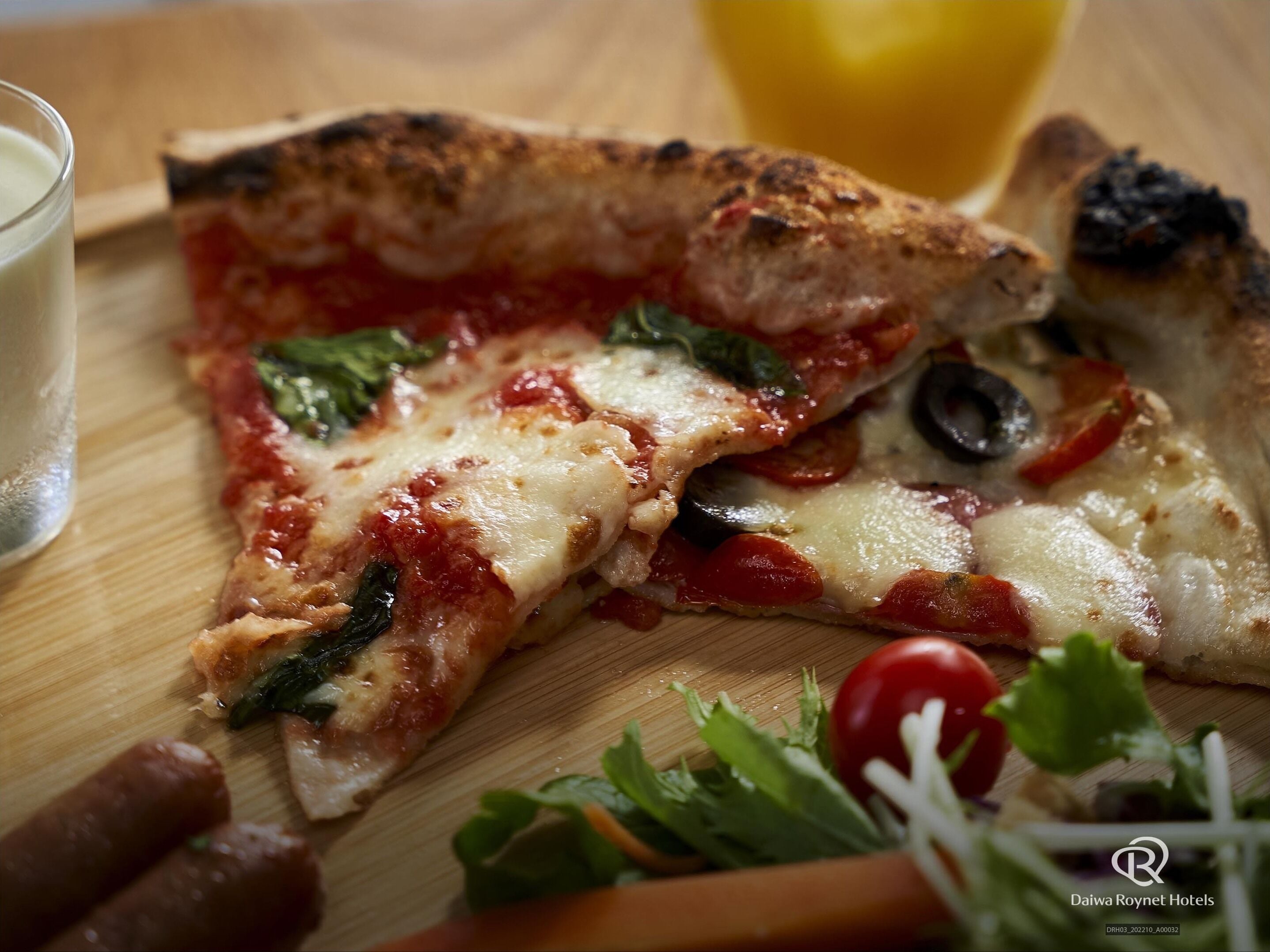 A pizza slice with toppings on a wooden board.