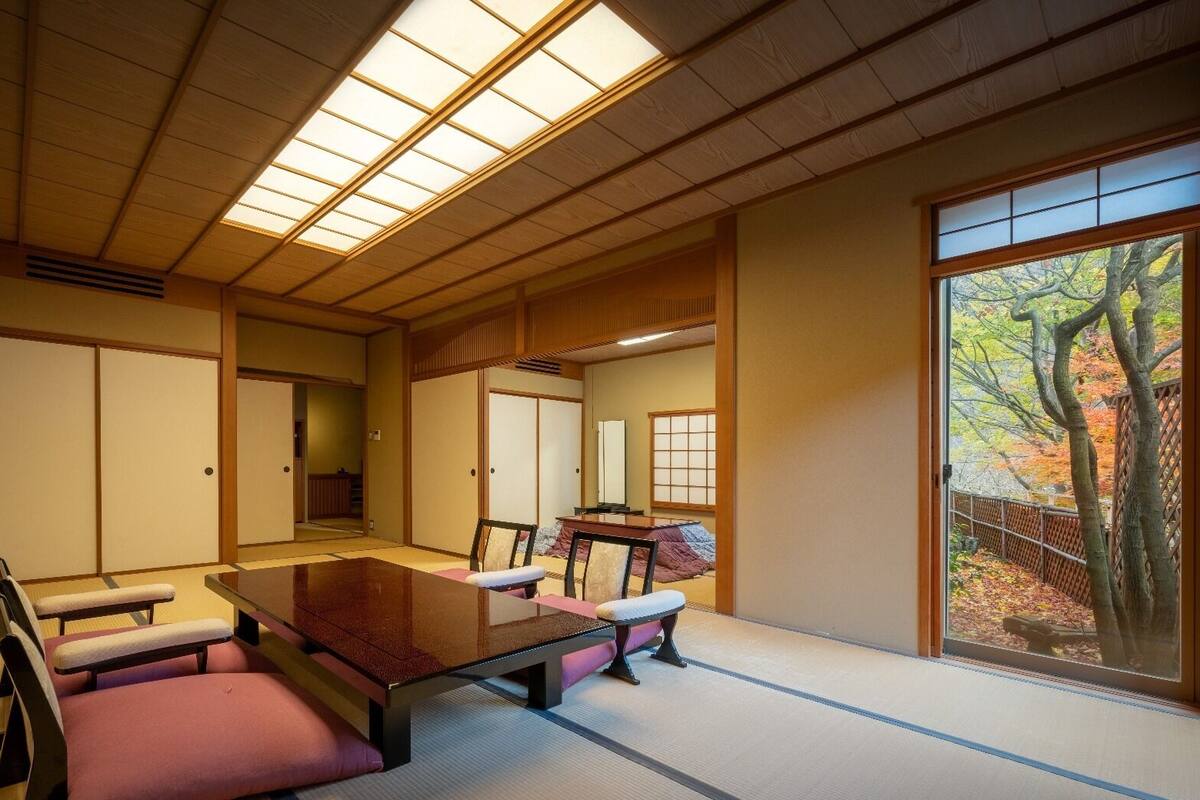 A traditional Japanese room with tatami flooring, a low table, and sliding doors.