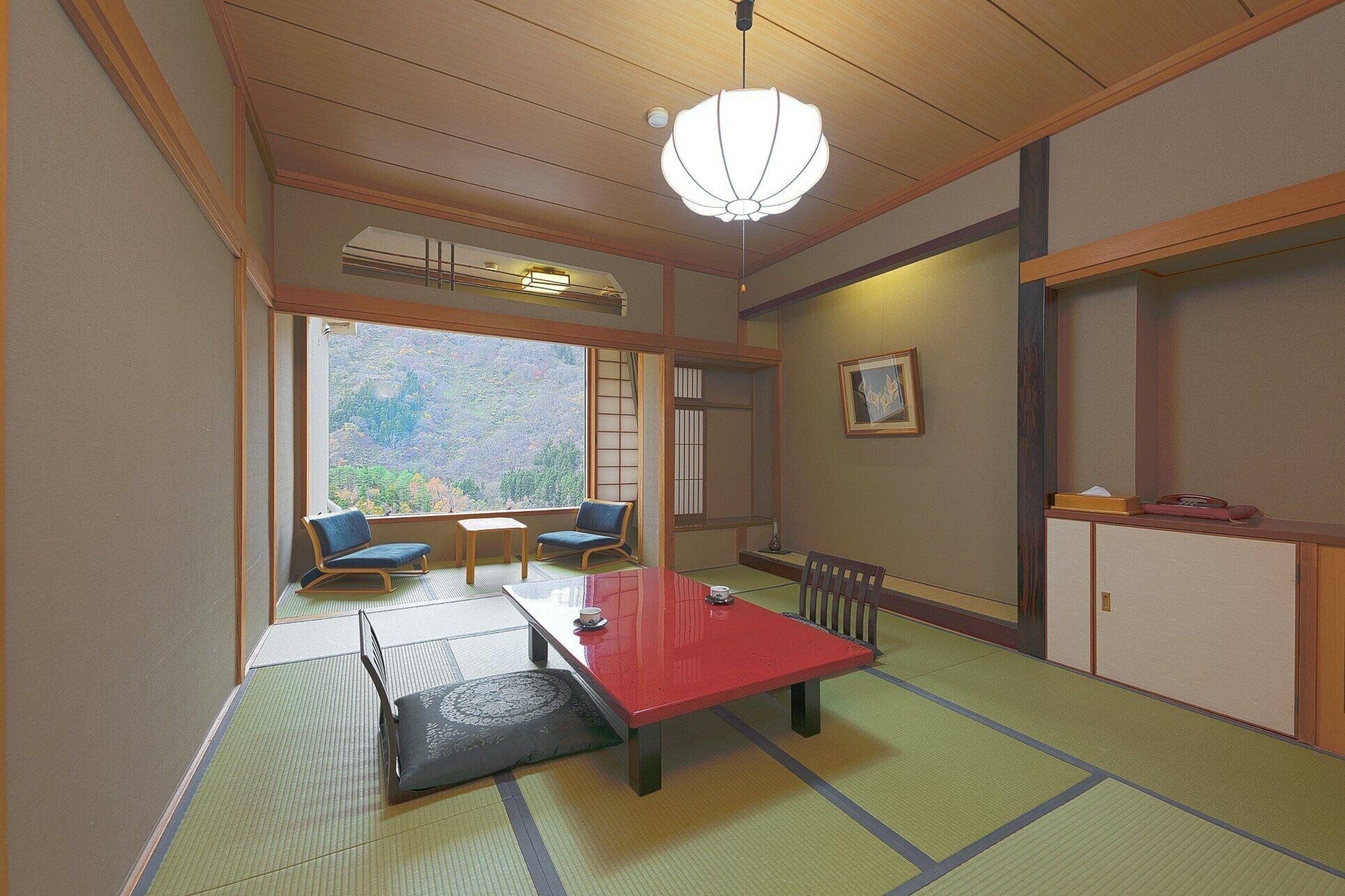 Une pièce de style japonais traditionnel, avec un sol recouvert de tatamis, une table basse et des sièges.