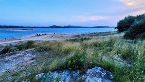 A coastal landscape with a beach, grassy areas, and distant hills. - Cozy Canyon Lake Tiny House – Stunning Views & Great Location (Canyon Lake)
