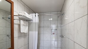 A modern bathroom with a toilet, sink, and shower. - American Inn (Baton Rouge)