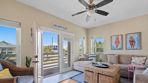 A spacious living room with a sofa, a coffee table, and a ceiling fan.