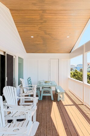 A covered outdoor deck with a wooden ceiling, white walls, and a view of the cityscape. - OCEAN VIEW, across from beach access, BEAUTIFULLY updated 4 bed,4 bath,sleeps 14 (Emerald Isle)