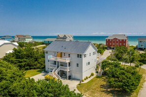 A two-story house with a balcony, a garage, and a view of the ocean. - OCEAN VIEW, across from beach access, BEAUTIFULLY updated 4 bed,4 bath,sleeps 14 (Emerald Isle)