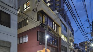 Un immeuble à plusieurs étages doté de balcons et d’une enseigne de restaurant bien visible.