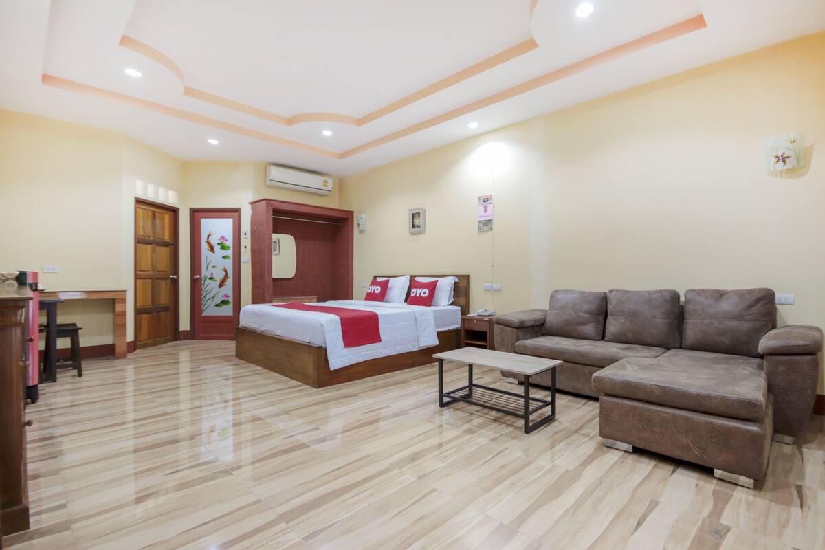 Habitació d'hotel amb llit, sofà, escriptori i cadira.