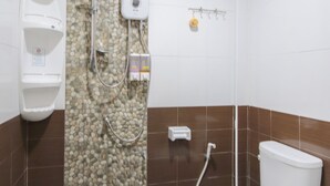 Ein Badezimmer mit Toilette, Dusche und einer wandmontierten Seifenspender.