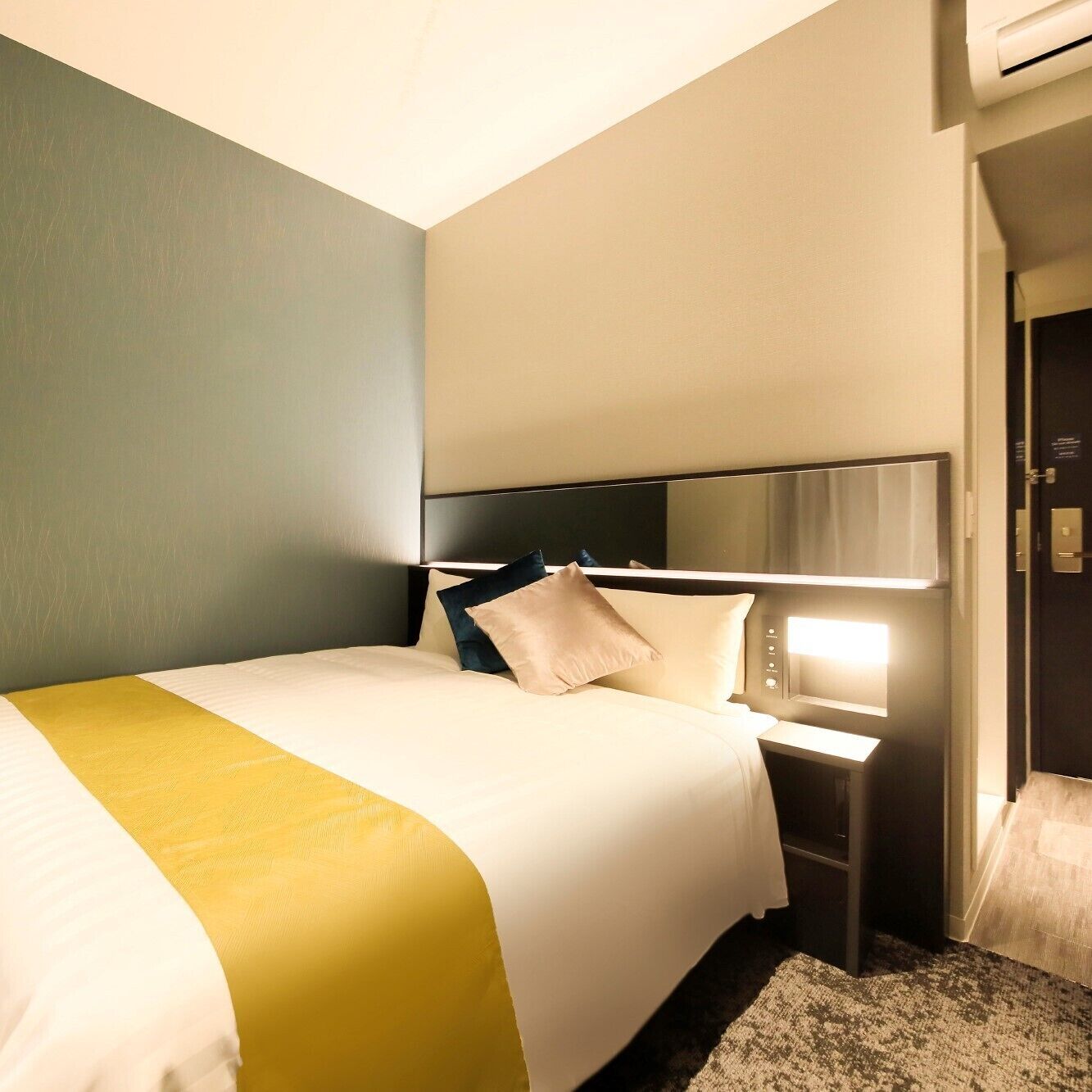 Une chambre d’hôtel avec un lit, une table de chevet et une petite table d’appoint.