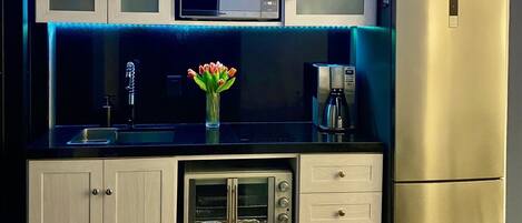 Une cuisine moderne équipée d’un four à micro-ondes, d’un grille-pain et d’un réfrigérateur.