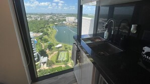 Une cuisine dotée d’une grande fenêtre donnant sur une rivière et sur le paysage urbain.