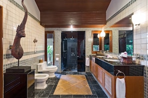 A modern bathroom with a shower, two toilets, a vanity with a sink, and a large mirror. - Villa Baan Hen 5 Bedroom Kata Beach (Karon)