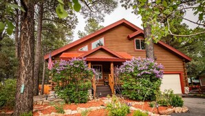 A log cabin with a red roof, a front porch, and a garage. - Hot Tub, Arcade Room, Fire Pit, 3 Min to Uptown Pagosa, Private Colorado Setting (Pagosa Springs)