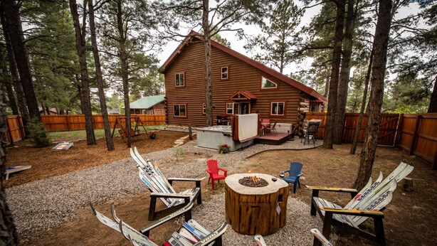A log cabin with a deck, outdoor seating, and a fire pit. - Hot Tub, Arcade Room, Fire Pit, 3 Min to Uptown Pagosa, Private Colorado Setting (Pagosa Springs)