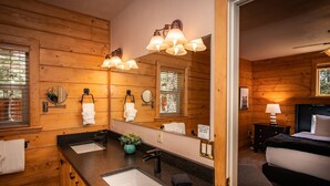 A wooden cabin-style bathroom with two sinks, a mirror, and a shower. - Hot Tub, Arcade Room, Fire Pit, 3 Min to Uptown Pagosa, Private Colorado Setting (Pagosa Springs)