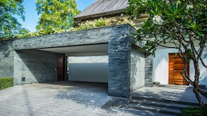 A modern house with a stone facade, a garage, and a wooden door. - Laemsingh Villa 3a 4 Bedroom in Surin (Kamala)