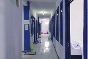 A long, narrow hotel corridor with blue-framed doors on both sides, leading to individual rooms. - KoolKost near Trans Studio Bandung 2 (Bandung)