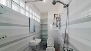 Un bany modern amb vàter, rentapel i plat de dutxa.