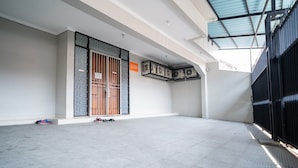 A spacious indoor area with a high ceiling, a large window, and a metal gate.