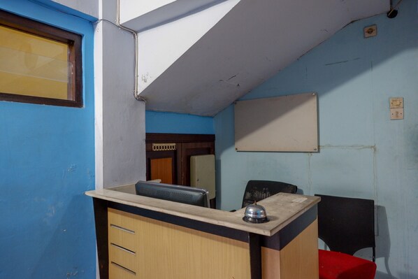 Una habitación pequeña y funcional con escritorio, una silla y una cama.