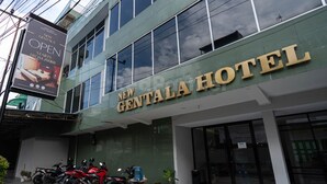 A hotel named 'New Gentala Hotel' with a modern facade, large windows, and a sign indicating it is open. - New Gentala Hotel RedPartner (Medan)