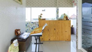 Un vestíbulo con un mostrador de recepción de madera, un banco y un reloj en la pared.