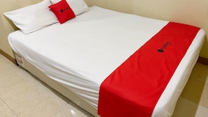 A single bed with a white mattress and a red blanket. - RedDoorz @ Jalan Morotai Lampung (Bandar Lampung)