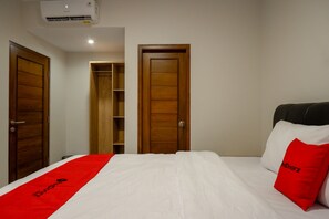 Una habitación de hotel con cama, armario y estantería.