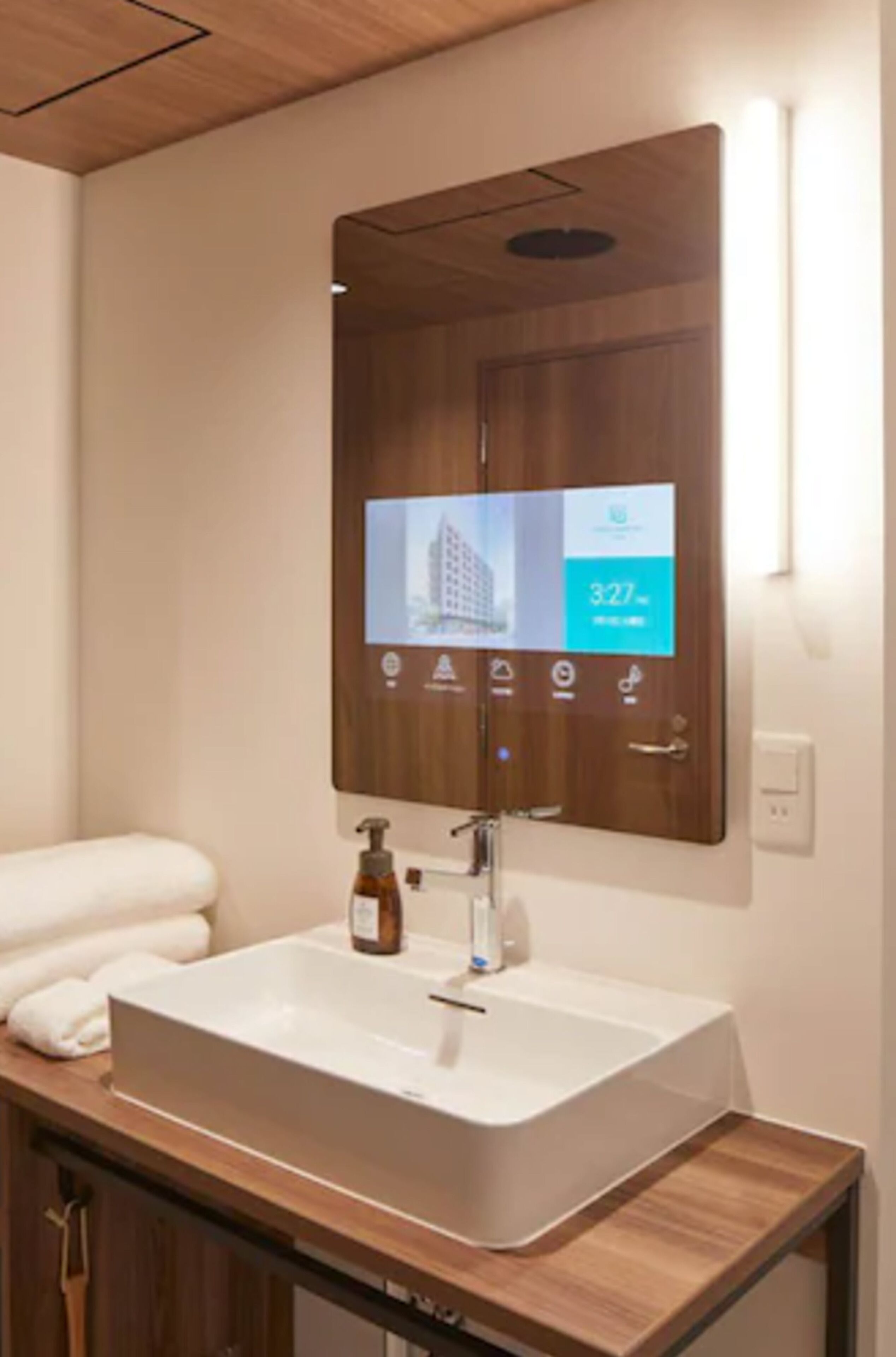 Un baño moderno con un espejo grande, un lavamanos blanco y un mueble de tocador de madera.