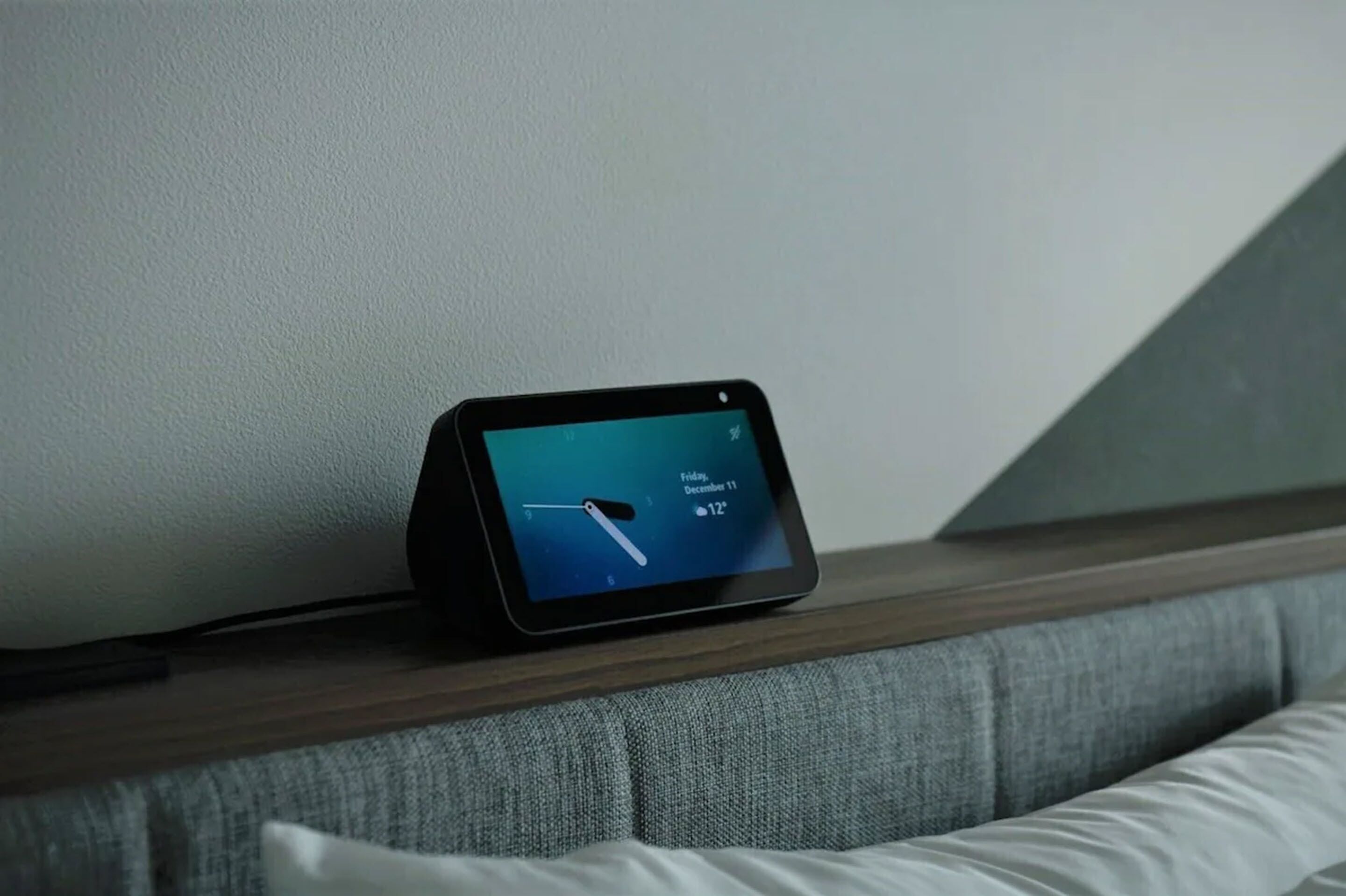 A tablet displaying a weather forecast on a wooden ledge.