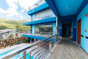 A multi-level blue building with a pool, outdoor seating, and a view of the surrounding landscape. - RedDoorz Premium @ Casa Ghilda Resort Olongapo City (Olongapo)
