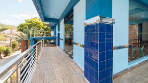 A covered outdoor area with a wooden deck, blue-tiled walls, and a glass door leading inside. - RedDoorz Premium @ Casa Ghilda Resort Olongapo City (Olongapo)
