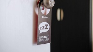 A door with a do not disturb sign and a key in the lock. - RedDoorz Plus @ Luzmin BH Lodging House (Oslob)