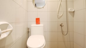 A bathroom with a toilet, a bidet, a shower, and a mirror on the wall. - RedDoorz Plus @ Jardin Suites Guadalupe Nuevo (Makati)