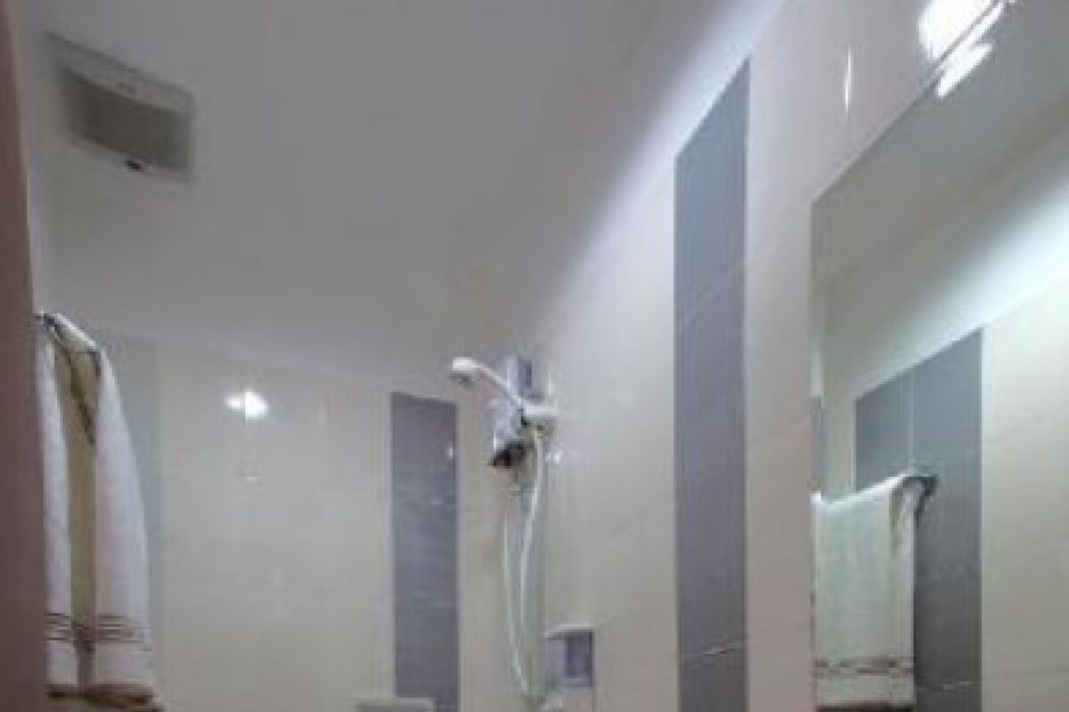 Un baño con inodoro, lavabo y ducha.