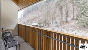A balcony with a wooden railing, a table, and chairs. - Apartment Brlog (Zgornje Gorje)