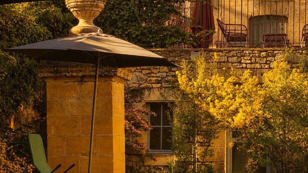 A stone building with a garden, a pergola, and outdoor seating. - Hôtel des Augustins - Boutique Hôtel - Restaurant Gastronomique (Saint-Cyprien)