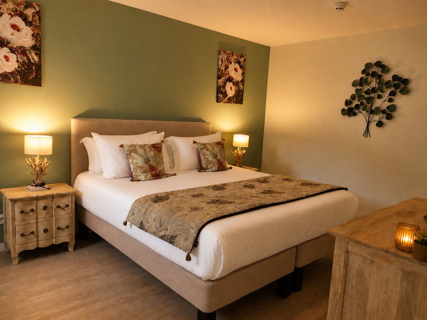 A neatly arranged bedroom with a bed, bedside tables, and wall art.