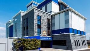 A modern hotel with a stone facade, blue and white exterior, and a visible logo. - NOA HOTEL Toyotaminami - Adults Only (Anjo)
