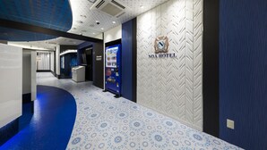 A hotel lobby with a patterned floor, a vending machine, and a reception desk. - NOA HOTEL Toyotaminami - Adults Only (Anjo)