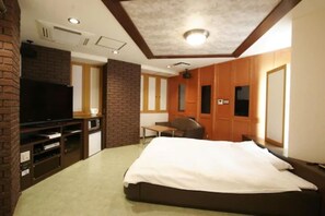 A hotel room with a bed, a TV, a desk, and a brick accent wall. - NOA HOTEL Toyotaminami - Adults Only (Anjo)