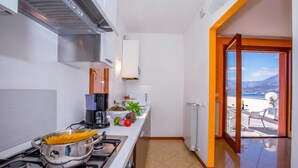 Een moderne keuken met een fornuis, een koffiezetapparaat en een kom pasta.