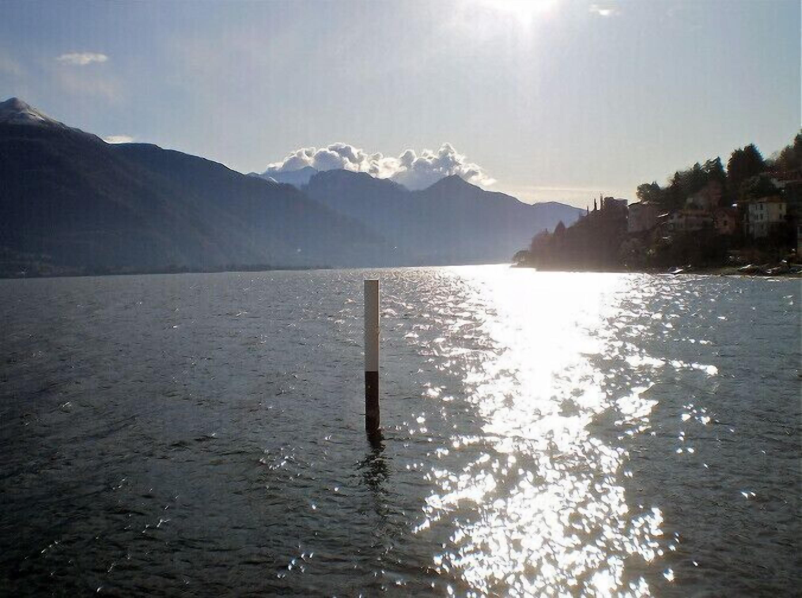 A body of water with mountains in the background and a clear sky.