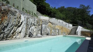 A swimming pool with stone steps leading up to a building, surrounded by greenery. - Casa Mastena Vista Lago (San Siro)